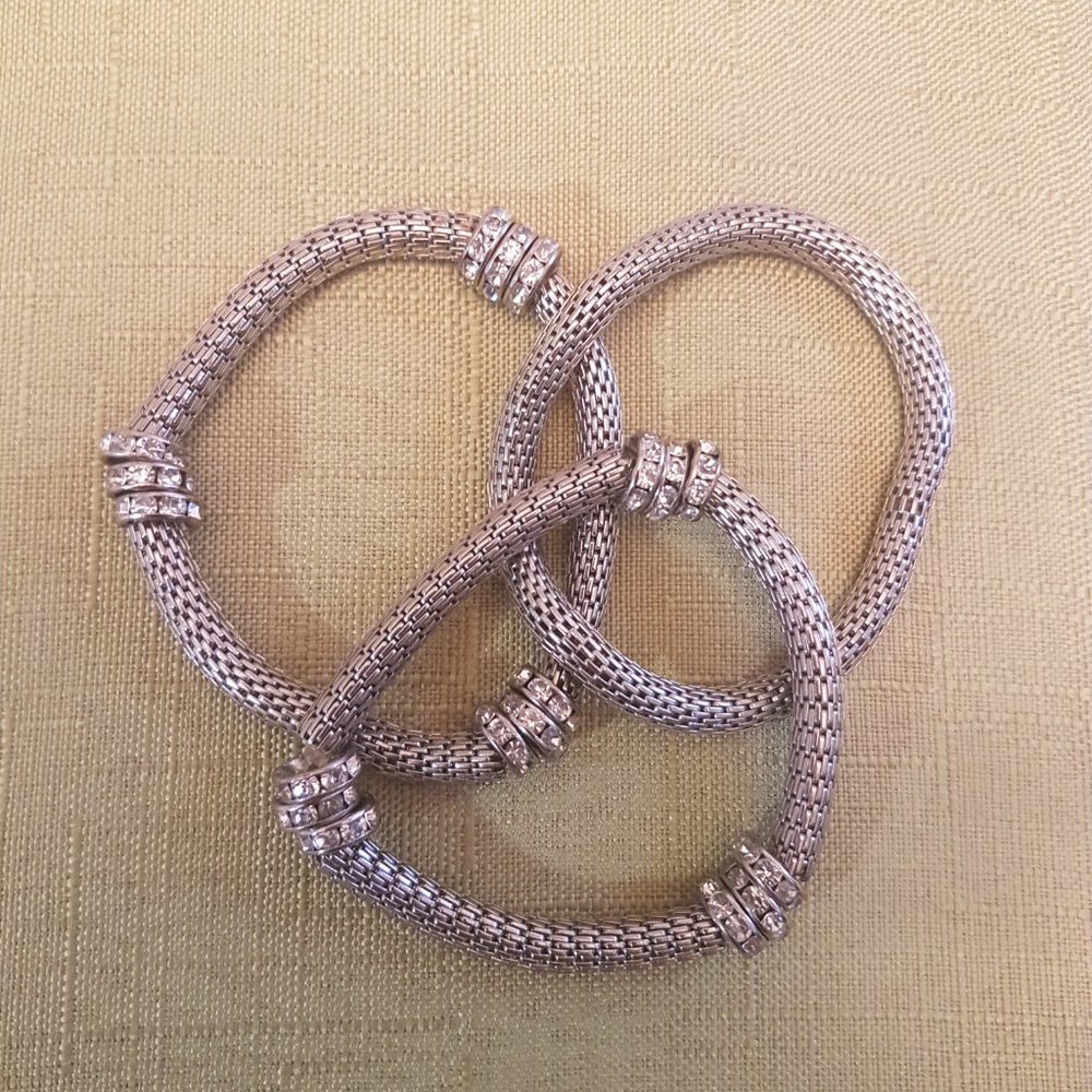 3 silver - tone bracelets.